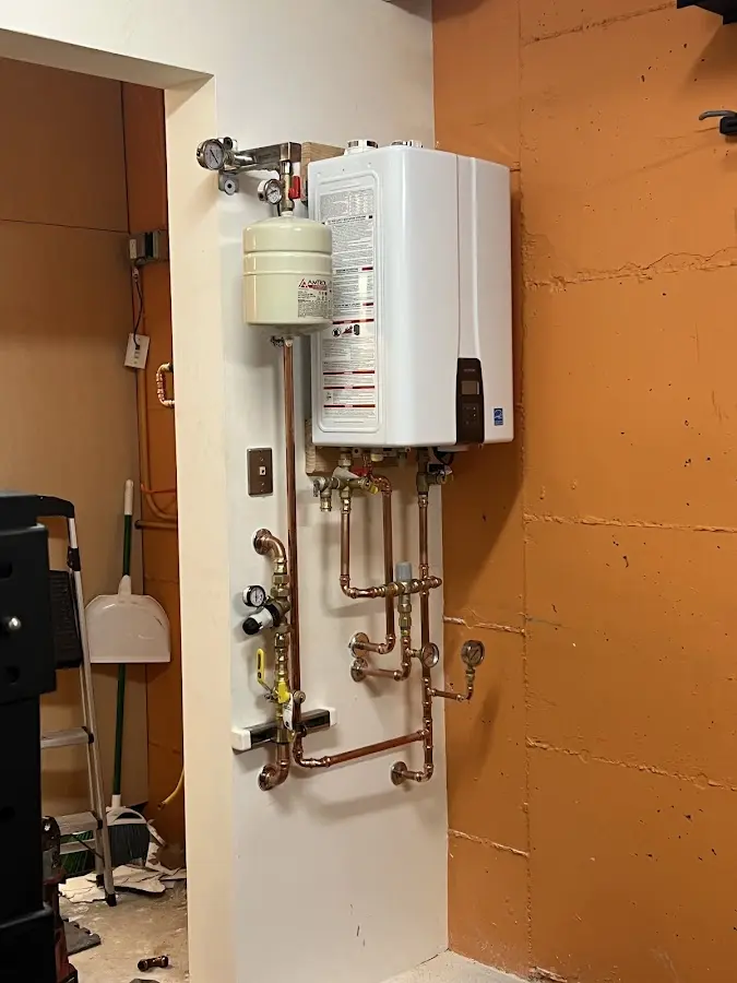Plumbing technician inspecting water heater connections in Wareham